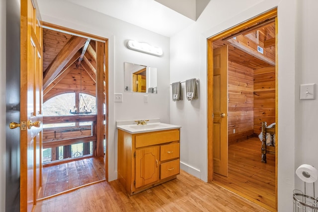 bathroom featuring wood walls, vanity, and hardwood / wood-style flooring