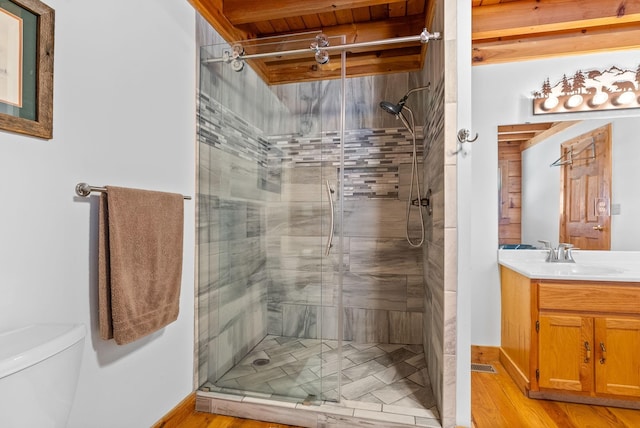 bathroom featuring vanity, wood finished floors, a shower stall, and toilet