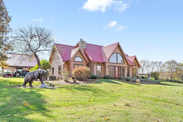 view of front of house with a front yard, a chimney, a standing seam roof, and metal roof