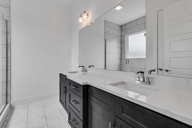 bathroom with double vanity, marble finish floor, baseboards, and a sink