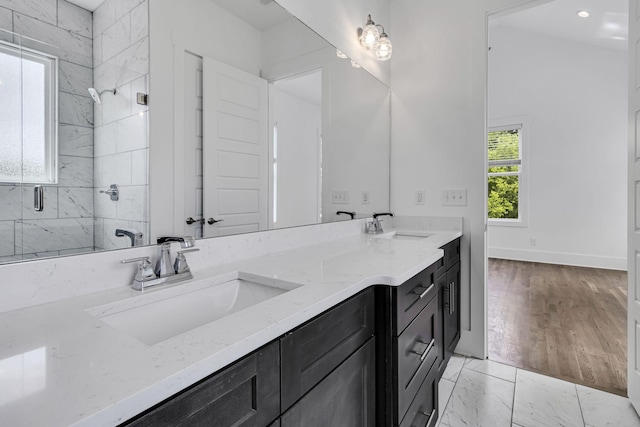 bathroom featuring a sink, a shower stall, and double vanity