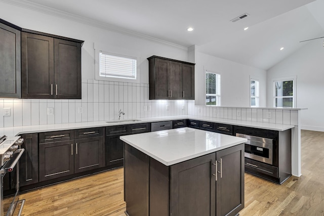 kitchen featuring a sink, stainless steel appliances, backsplash, and light countertops