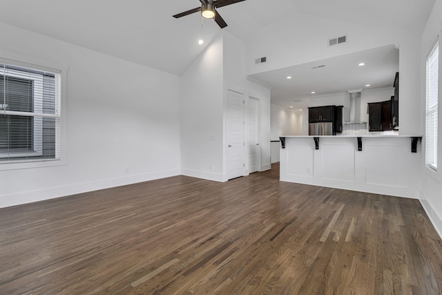 unfurnished living room featuring visible vents, high vaulted ceiling, a ceiling fan, dark wood-style floors, and baseboards