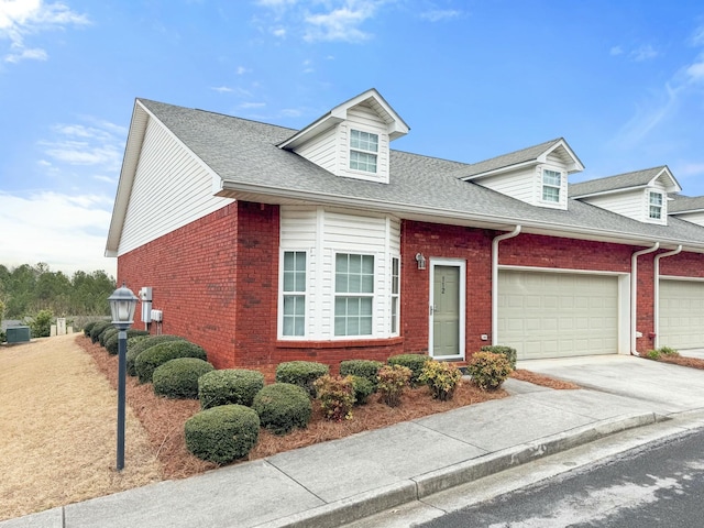 cape cod house with brick siding, roof with shingles, concrete driveway, and an attached garage