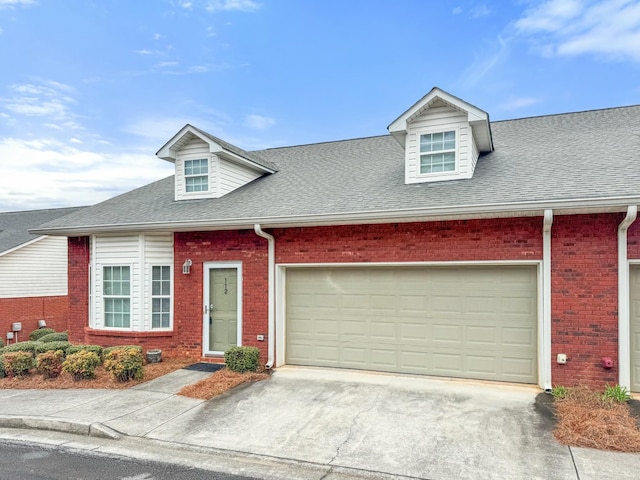 view of front of property featuring brick siding, driveway, a shingled roof, and a garage