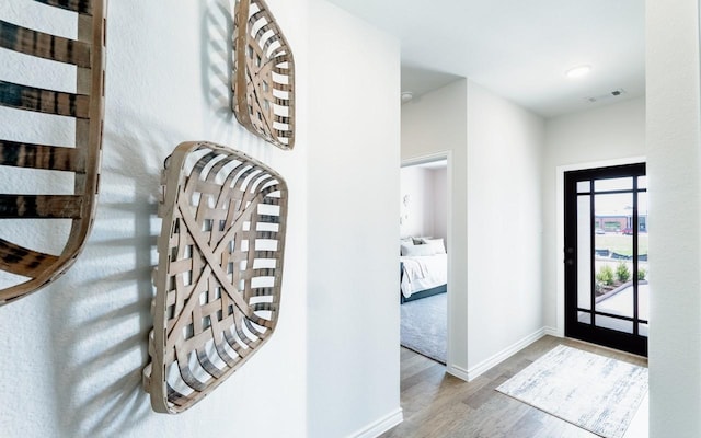 entrance foyer featuring visible vents, baseboards, and wood finished floors