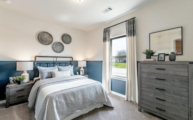 carpeted bedroom with visible vents and baseboards