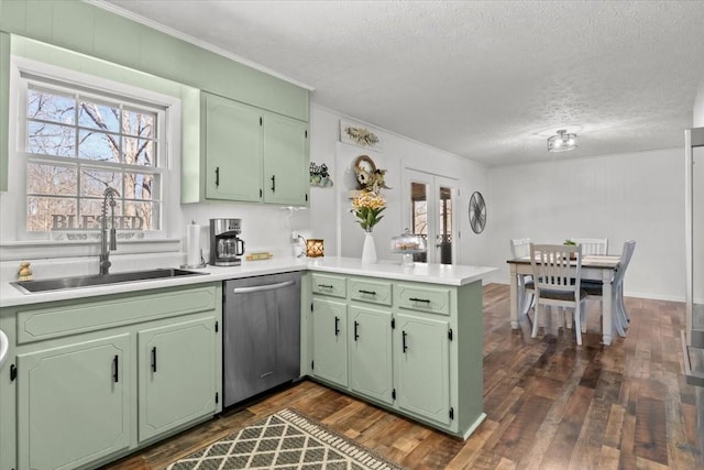 kitchen featuring green cabinets, dark wood-style flooring, a peninsula, stainless steel dishwasher, and a sink