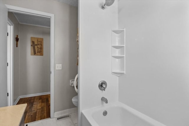 bathroom featuring visible vents, toilet, washtub / shower combination, baseboards, and vanity