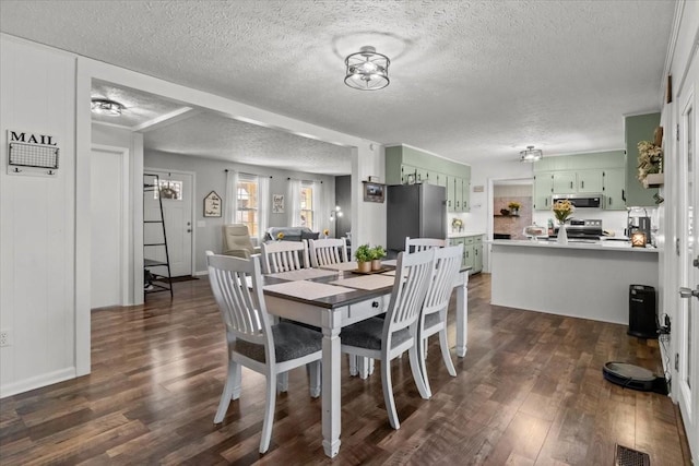 dining area with visible vents, dark wood-style flooring, and a textured ceiling