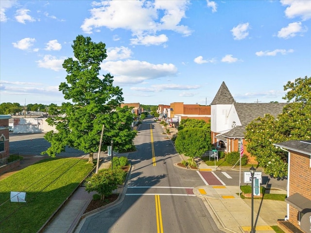 view of road featuring curbs, traffic signs, and sidewalks