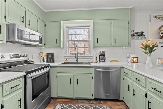 kitchen featuring green cabinetry, appliances with stainless steel finishes, and a sink