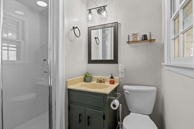 bathroom with a stall shower, toilet, and vanity