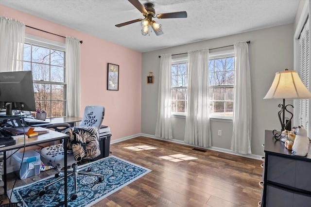 office area with visible vents, a ceiling fan, a textured ceiling, wood finished floors, and baseboards