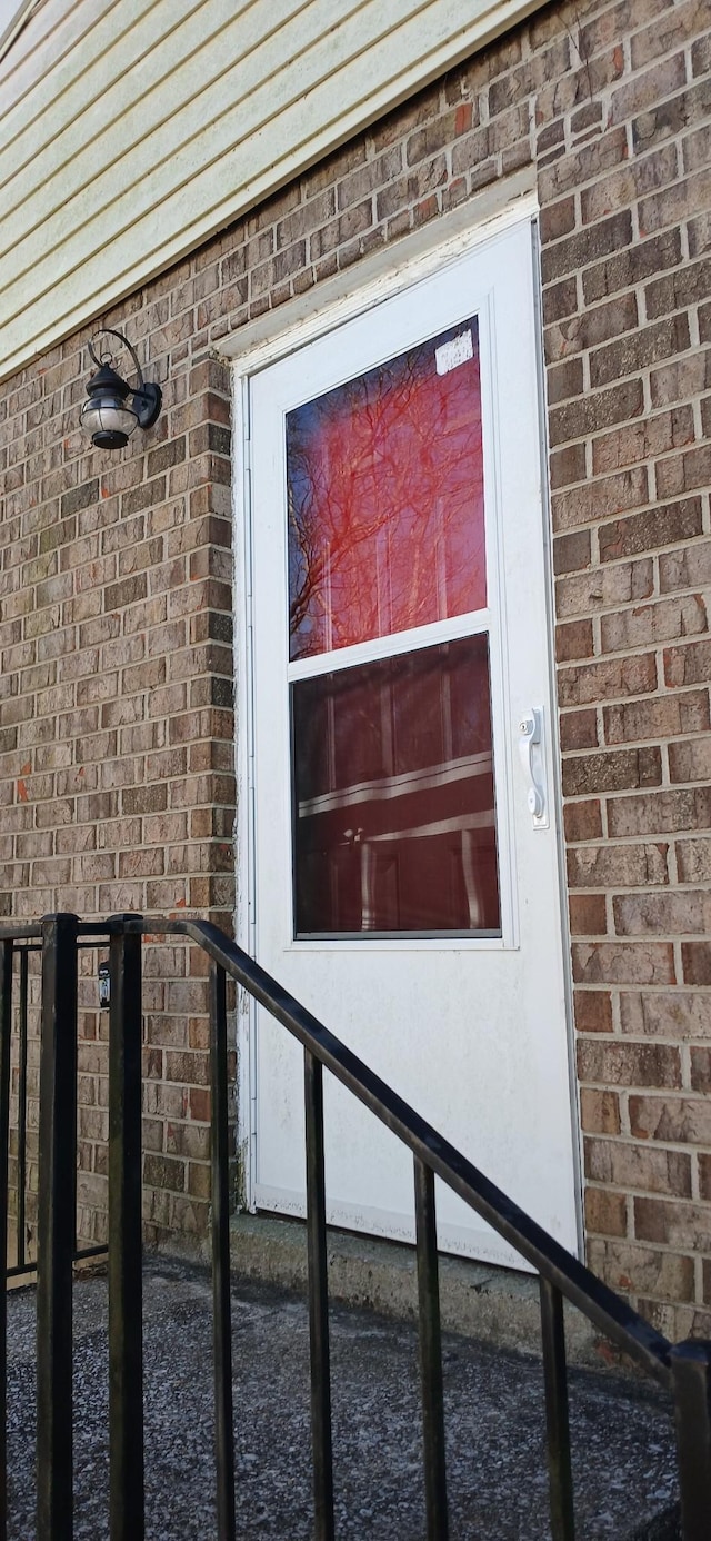 doorway to property with brick siding