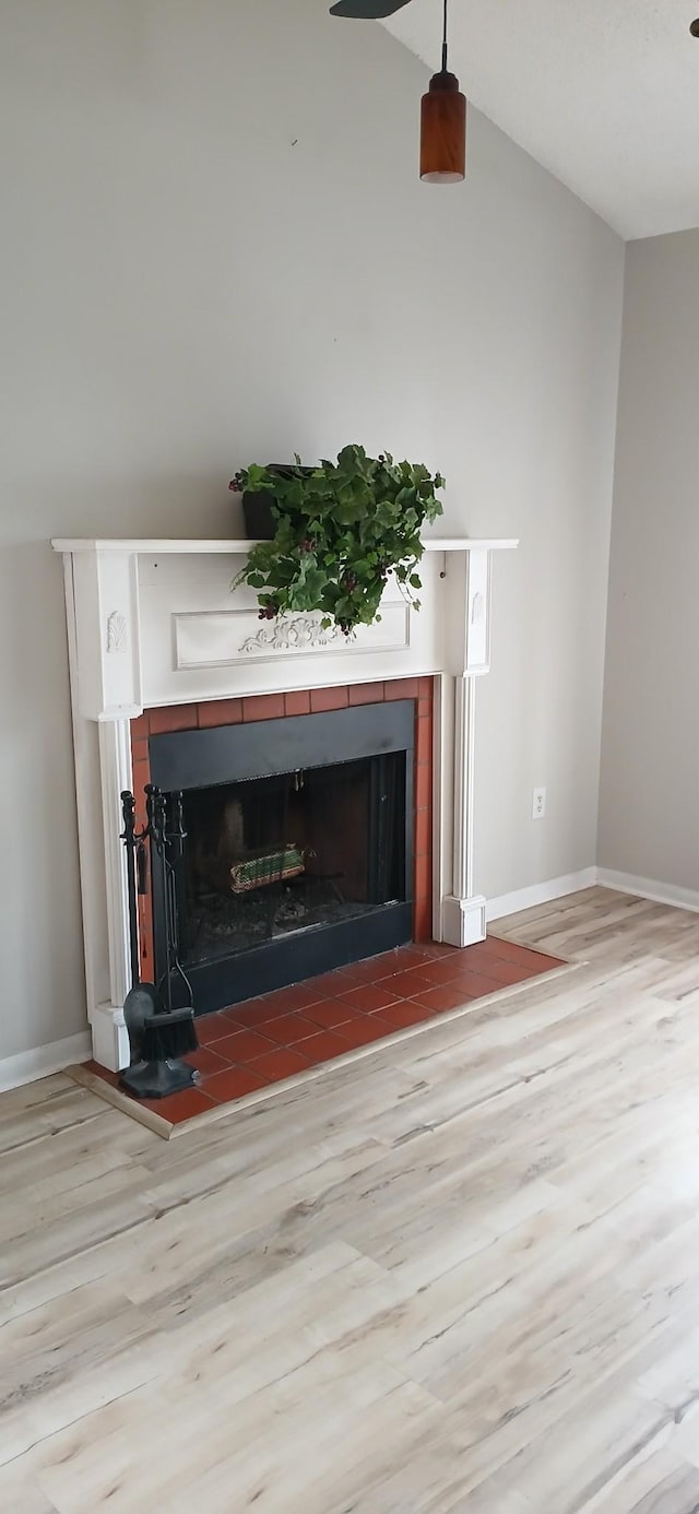 interior details with a fireplace, baseboards, and wood finished floors