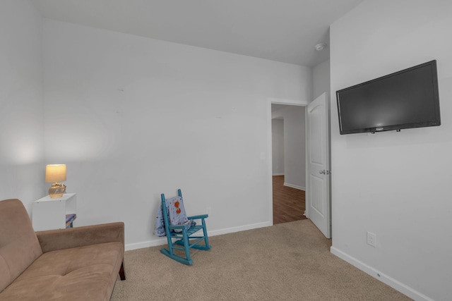 living area with baseboards and carpet