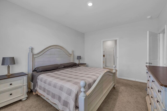 bedroom featuring connected bathroom, baseboards, and light carpet