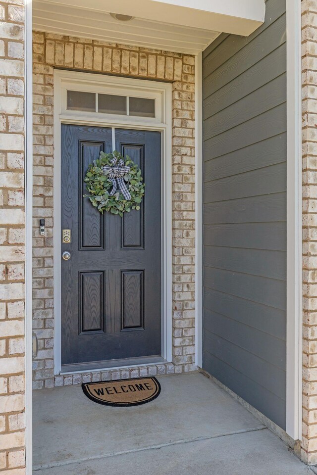 doorway to property featuring brick siding