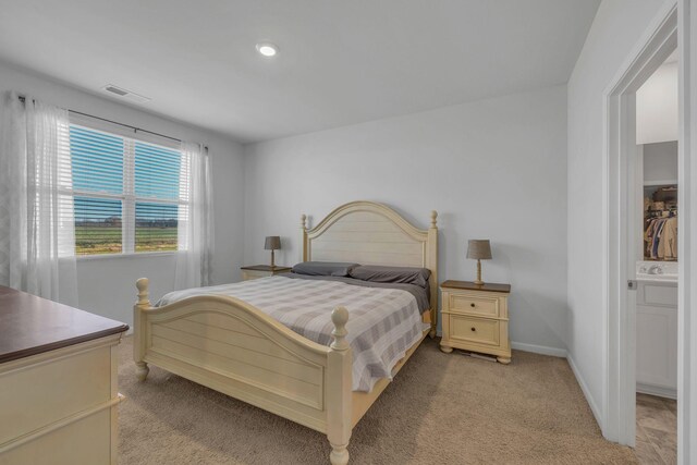 bedroom featuring visible vents, baseboards, and light colored carpet