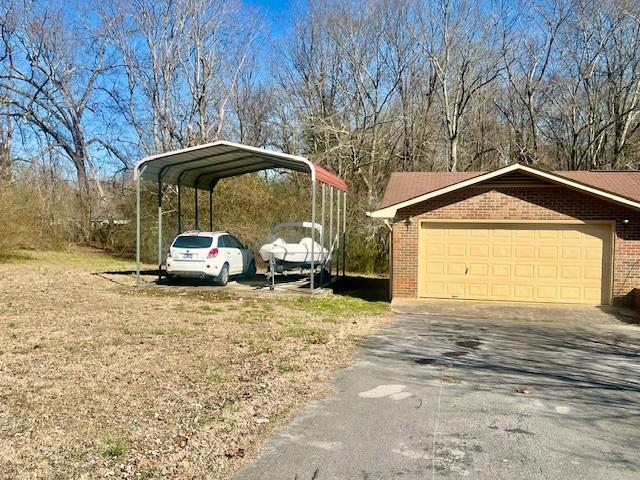 exterior space with a garage, a carport, and driveway