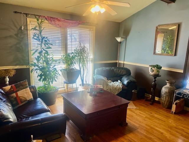 living area with light wood finished floors, ceiling fan, and vaulted ceiling