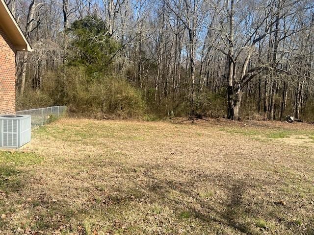 view of yard featuring central AC unit and fence