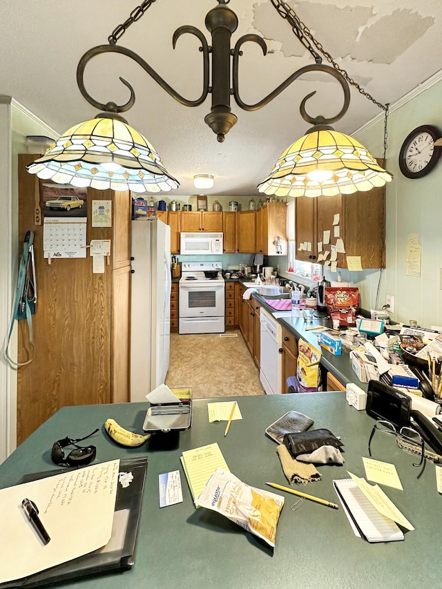 kitchen with a sink, dark countertops, white appliances, brown cabinetry, and crown molding