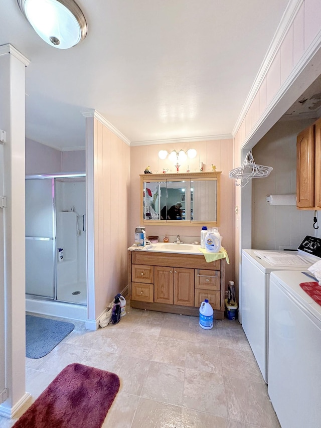 bathroom with washer and dryer, vanity, ornamental molding, and a shower stall