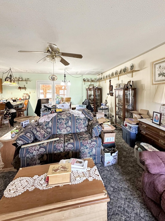 carpeted living area with a textured ceiling and a ceiling fan