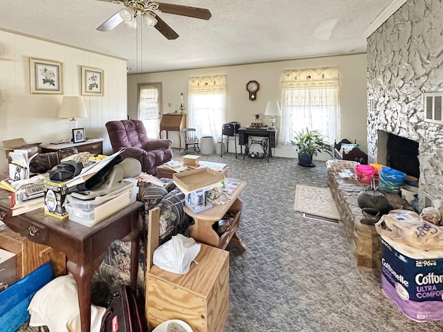 carpeted living room with a stone fireplace, ceiling fan, and a textured ceiling