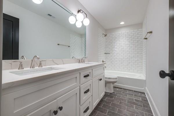 full bath with visible vents, toilet, a sink, double vanity, and shower / bath combination