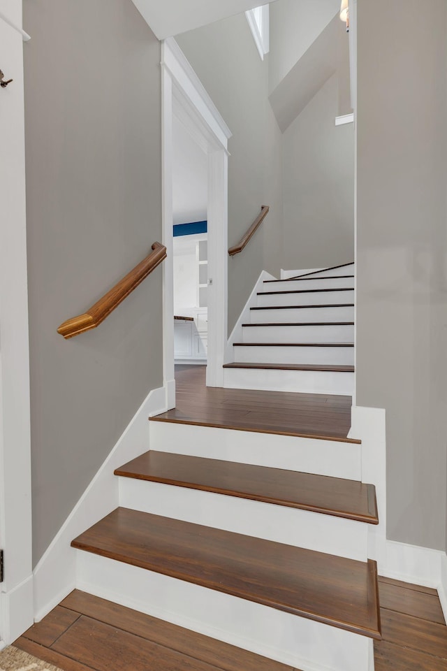 staircase with wood finished floors and baseboards