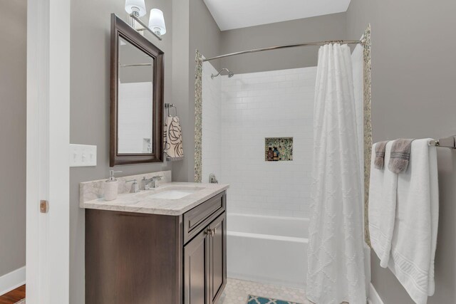 full bathroom with vanity, baseboards, and shower / bathtub combination with curtain