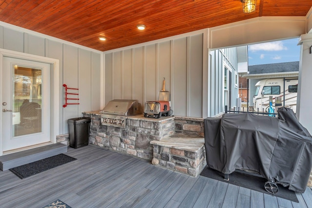 wooden terrace with an outdoor kitchen and a grill