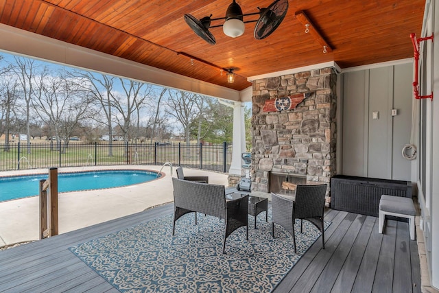 view of pool with a fenced backyard, a fenced in pool, and an outdoor stone fireplace