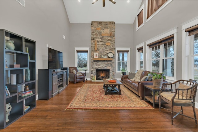 living area featuring visible vents, a fireplace, high vaulted ceiling, and hardwood / wood-style floors