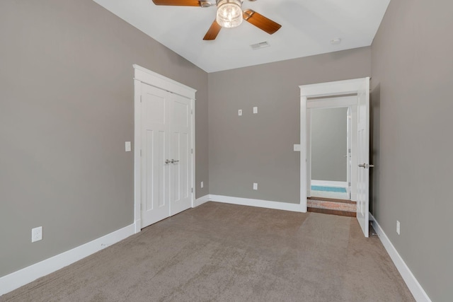 unfurnished bedroom with visible vents, ceiling fan, baseboards, carpet, and a closet