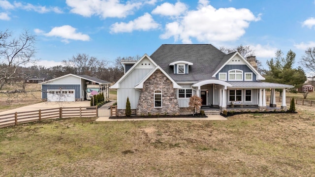 view of front of home featuring stone siding, covered porch, board and batten siding, and fence private yard