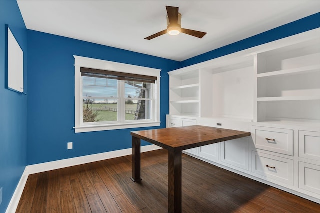 unfurnished office featuring baseboards, dark wood-type flooring, and a ceiling fan