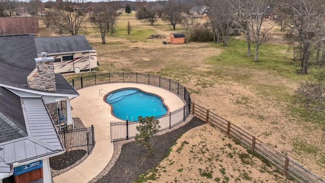 view of swimming pool featuring an outdoor structure, fence, a fenced in pool, and a patio