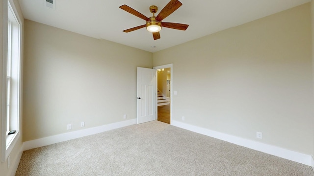 unfurnished room with visible vents, baseboards, carpet, and ceiling fan