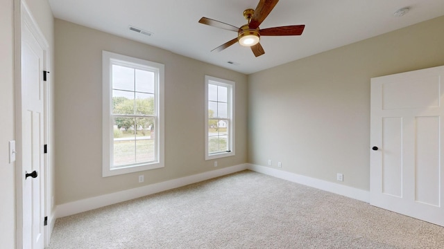 spare room featuring visible vents, baseboards, light colored carpet, and a ceiling fan