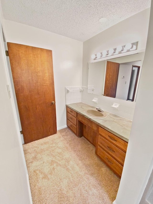 bathroom with baseboards, a textured ceiling, and vanity