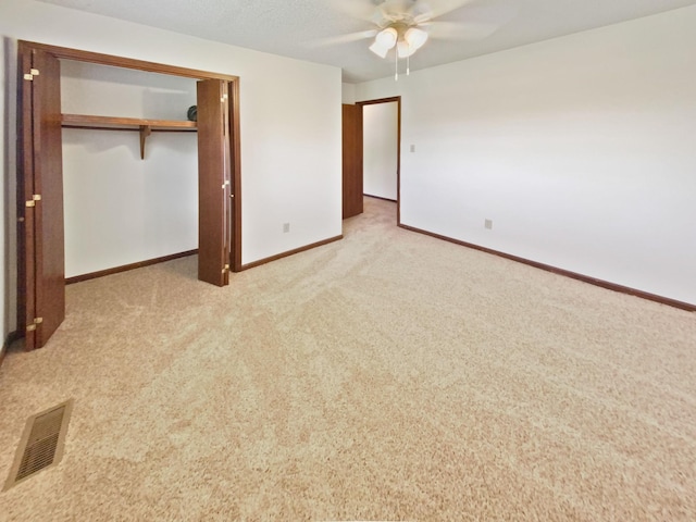 unfurnished bedroom with visible vents, a ceiling fan, a closet, carpet flooring, and baseboards