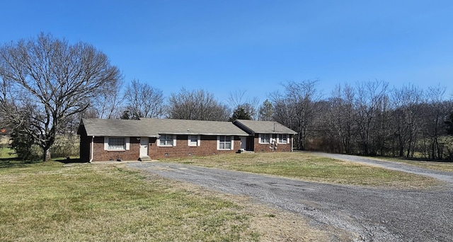 ranch-style home featuring a front lawn, brick siding, driveway, and crawl space