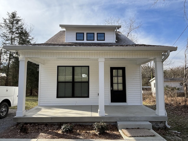 bungalow-style home featuring a porch and a shingled roof