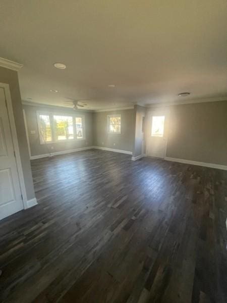 unfurnished room with dark wood-type flooring, baseboards, and ornamental molding