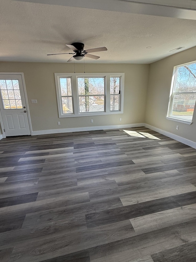 spare room with a healthy amount of sunlight, baseboards, and a textured ceiling