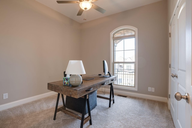 home office with light carpet, visible vents, ceiling fan, and baseboards